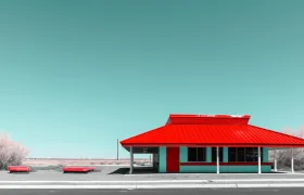 Red-roofed Pizza Hut style restaurant building beside an empty highway