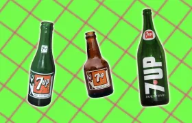 Three vintage 7 Up glass bottles with paper and painted labels
