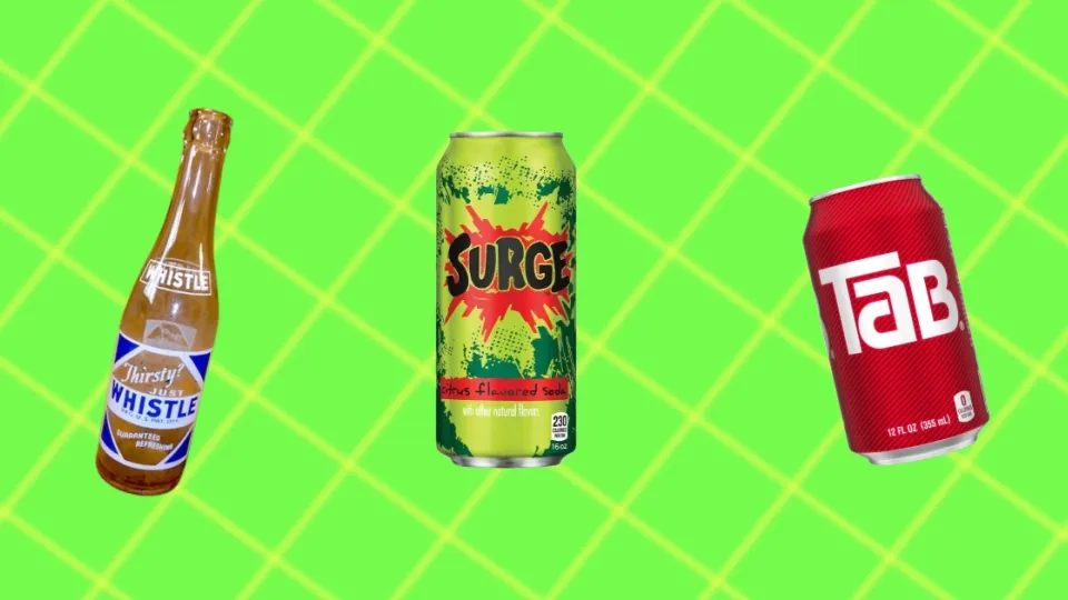 Vintage Whistle soda bottle beside a Surge can and a red Tab can