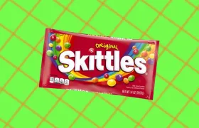 Original Skittles candy bag on a green grid background