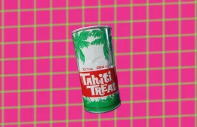 Vintage Tahiti Treat soda can with palm trees on pink background
