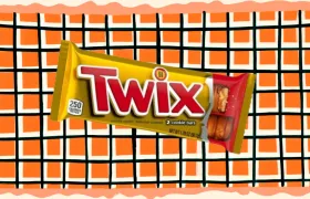 Twix candy bar in gold wrapper on orange checkered background