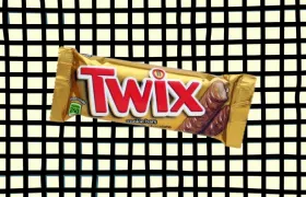 Twix candy bar in gold wrapper on checkered background