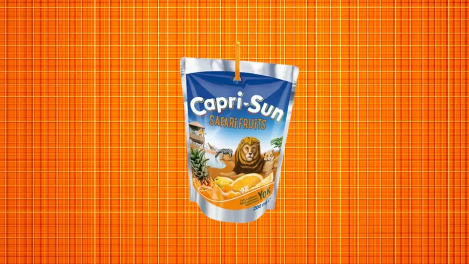 Capri-Sun Safari Fruits juice pouch with straw on orange background